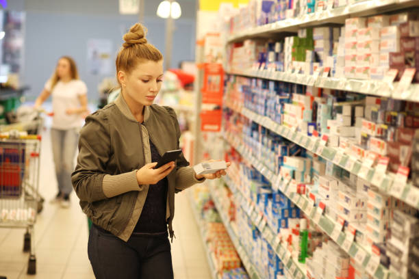 mujer de compras en el supermercado leyendo información del producto. - supermarket meat women packaging fotografías e imágenes de stock