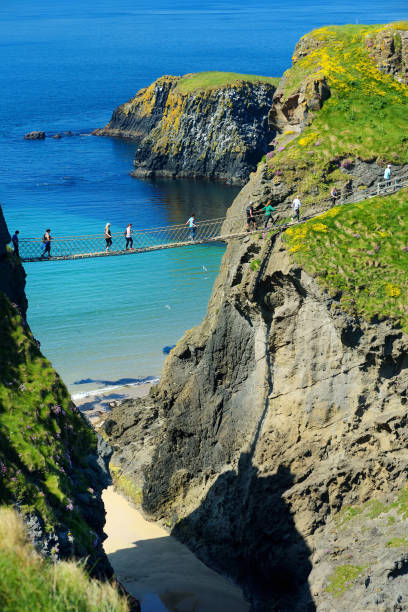 puente de cuerda carrick-a-rede, famoso puente cerca ballintoy en county antrim, une el continente con la isla pequeña de carrickarede - carrick a rede fotografías e imágenes de stock