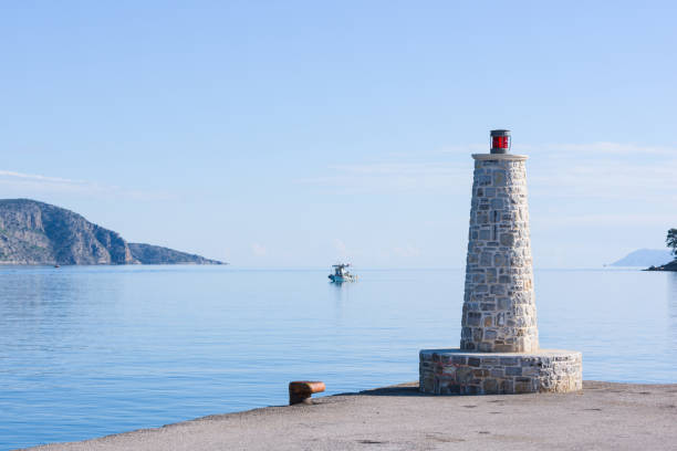 Beacon light with stone base, in Ermioni port near Nafplio, Greece.