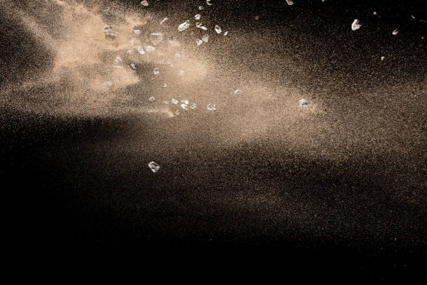 istock Golden sand with stone explosion isolated on black background. Abstract sand cloud. 1017213536