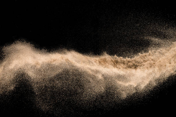 istock Dry river sand with stone explosion. Golden colored sand splash against dark background. 1017213548
