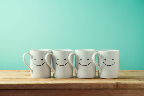 istock Coffee cups with funny faces on wooden table 1017215928