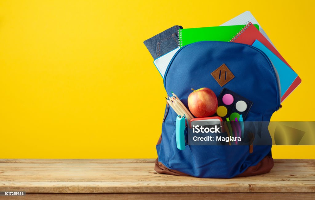 School bag backpack with notebooks School bag backpack with notebooks, smart phone and pencils over yellow background. Back to School Stock Photo