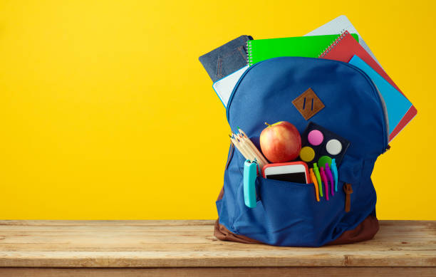 School bag backpack with notebooks School bag backpack with notebooks, smart phone and pencils over yellow background. back to school photos stock pictures, royalty-free photos & images