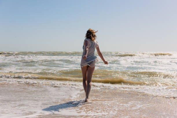 istock Happy female move and dance on seaside during day. 1017216836