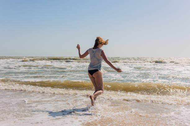 istock Happy playful female dance on seaside during day. 1017216890