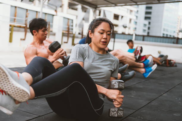 Circuit training and healthy lifestyle in Asia Portrait of healthy people exercising during summer heat and high humidity in the air in South East Asia. Athletes on cross training session. circuit training stock pictures, royalty-free photos & images