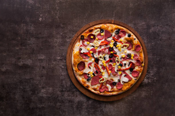 黒の背景にチーズとサラミ、トマトの自家製ピザ - thin portion salami meat ストックフォトと画像