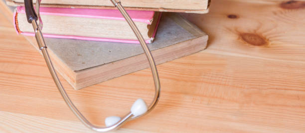 istock Stethoscope on book on wooden table banner 1017261016