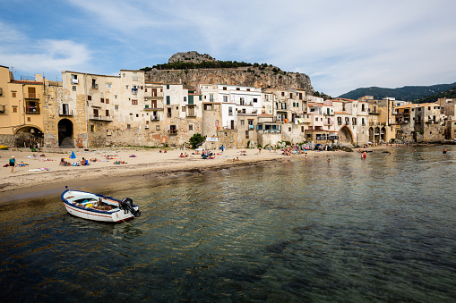 Cefalù,Sicily,Italy-20 June 2018:This is the little beach of old port of Cefalù where we can see many tourists tanning on the beach, others bathe and still others strolling