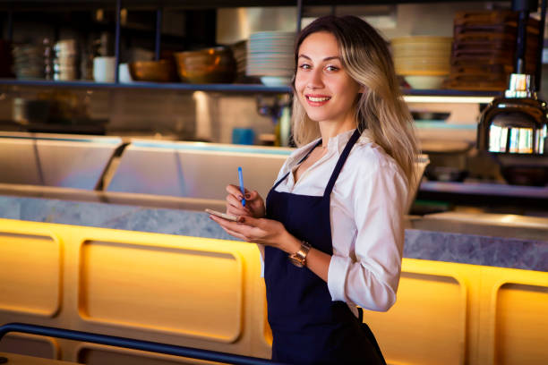 istock Business owner at her coffee shop looking at camera smiling while taking notes on a notepad 1017287612