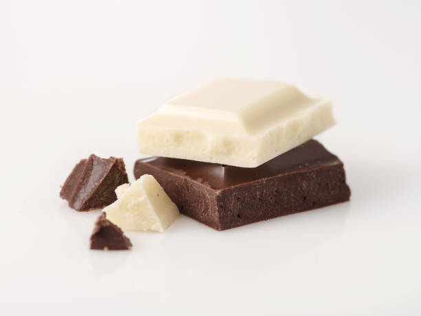 White chocolate chunks photographed on a white reflective background.