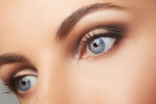 gros plan de beaux yeux humains. jeune femme bleu shoot de macro d’yeux. closeup oeil de macro - front view photos photos et images de collection