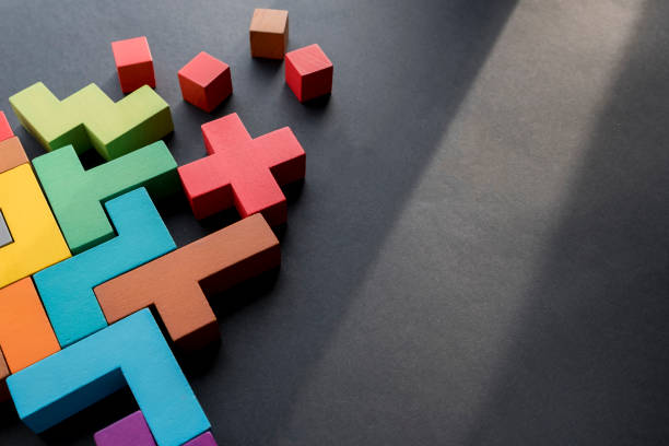 Different colorful shapes wooden blocks on black background, flat lay. Geometric shapes in different colors, top view. Concept of creative, logical thinking or problem solving. Copy space Different colorful shapes wooden blocks on black background, flat lay. Geometric shapes in different colors, top view. Concept of creative, logical thinking or problem solving. block stacking video game stock pictures, royalty-free photos & images