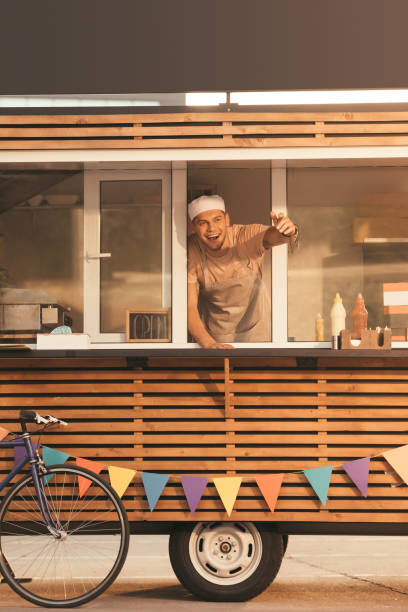 istock smiling chef gesturing and calling someone from food truck 1017338184