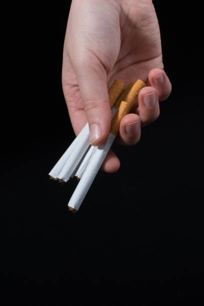 istock Hand is giving out bundle of cigarettes on black 1017343550