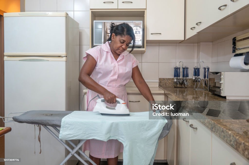Brazilian Maid Ironing Cloth In The Kitchen Stock Photo - Download Image  Now - 50-59 Years, Adult, Adults Only - iStock