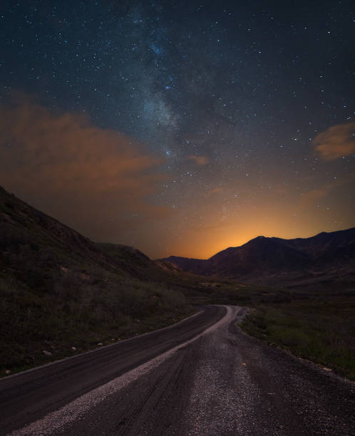 istock Dirt road in the mountains under the milky way 1017367608