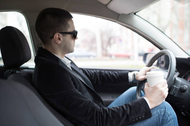 istock Businessman driving car and drinking coffee 1017387646