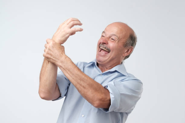 istock Alien hand syndrome. Mature man trying to control his hand. 1017387694