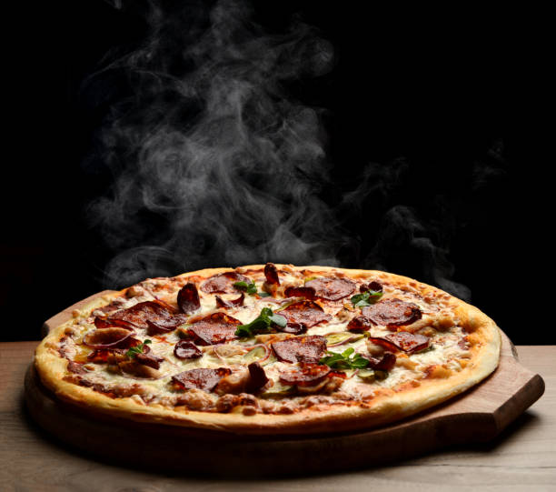 istock Hot big pepperoni pizza tasty pizza composition with melting cheese bacon tomatoes ham paprika steam smoke 1017408406