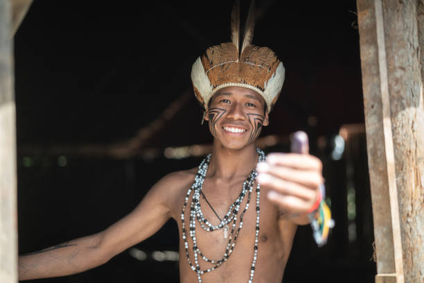 indígenas brasileños jóvenes hombre retrato de etnia guaraní, mostrando su casa - viaje al amazonas fotografías e imágenes de stock