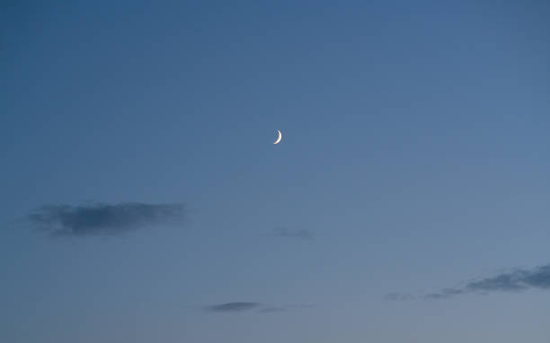 istock Twilight clear blue sky with perfect crescent moon and clouds for background 1017437784