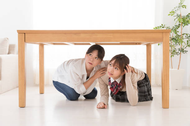 istock asian mother and daughter escaping under a table 1017437786