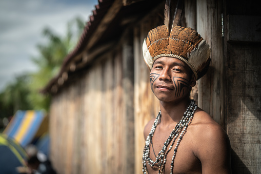 Retrato de hombre joven brasileño indígenas de la etnia guaraní en el hogar photo
