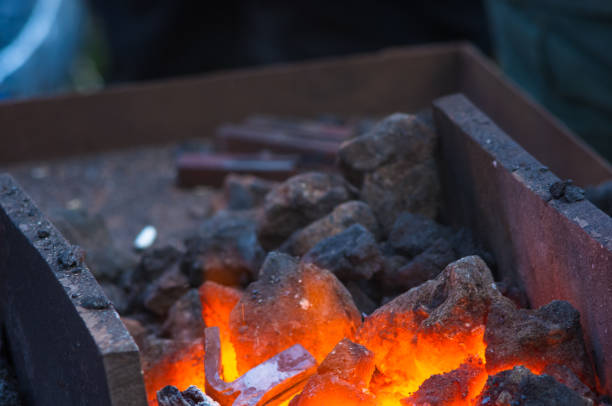 istock blacksmith performs the forging of hot glowing metal on the anvil 1017452908