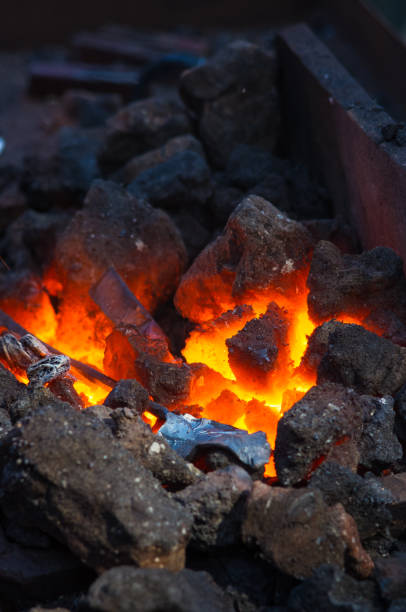 istock blacksmith performs the forging of hot glowing metal on the anvil 1017463078