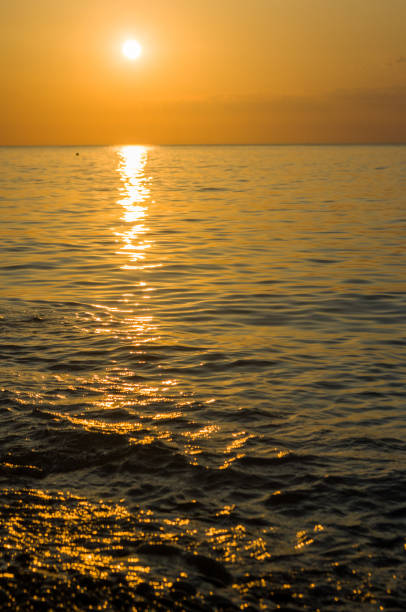 istock Amazing sea sunset on the pebble beach, the sun, waves, clouds 1017472050