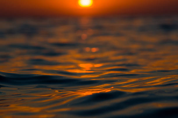 Summer sea sunset, the sun, waves and clouds, beautiful dramatic lightingSummer sea sunset on the pebble beach, the sun, waves and clouds, beautiful dramatic lighting