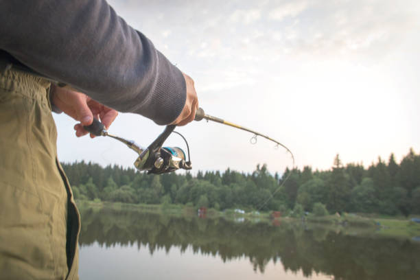 istock A man catches a fish with a rod in his hands. 1017519730