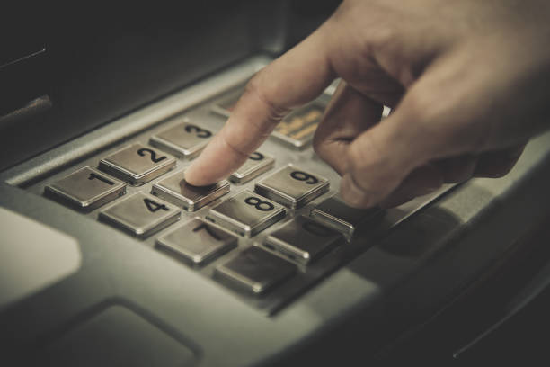Close up people hand press the number on ATM keypad in banking finance concept stock photo