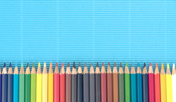 Colorful pencils on blue paper background stock photo