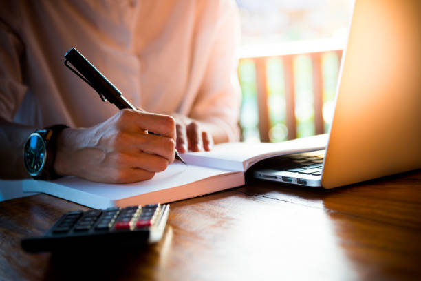 istock Close up women hand on writng on notebook and work with calculator 1017528948