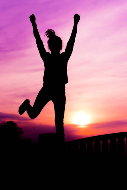 Silhouette of the women in the sunset with happy celebrating stock photo