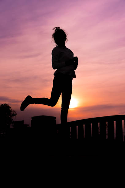 Silhouette of the women in the sunset with happy celebrating stock photo