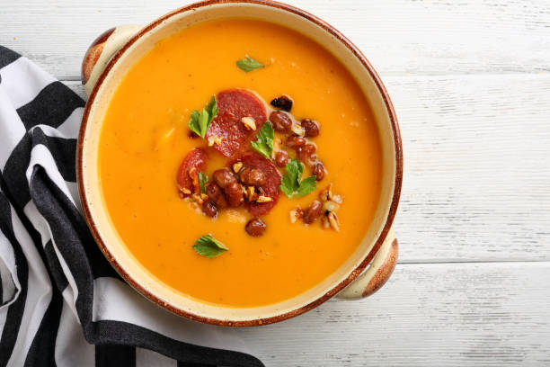 Hot pumpkin soup with chorizo and beans, food top view stock photo