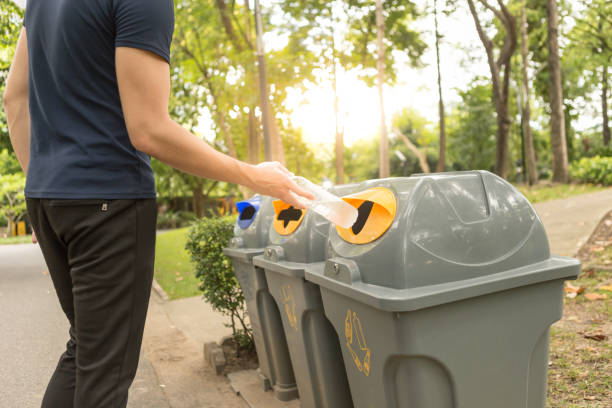 istock Close up of men hand put empty drinking water bottle in separate trash. Environmental care concept. 1017538964