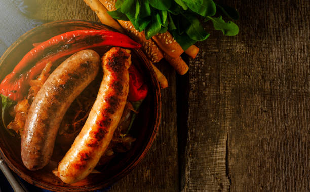 istock Grilled sausages and stewed cabbage on a wooden table. Rustic style. 1017554104