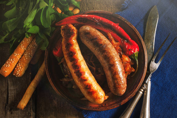 istock Grilled sausages and stewed cabbage on a wooden table. 1017554120