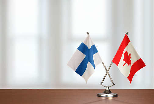 Two crossed national flags on wooden table