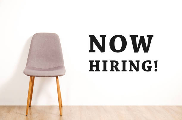 istock Head hunting help wanted poster concept. Minimalistic composition with chair and blank copy space wall. 1017577200