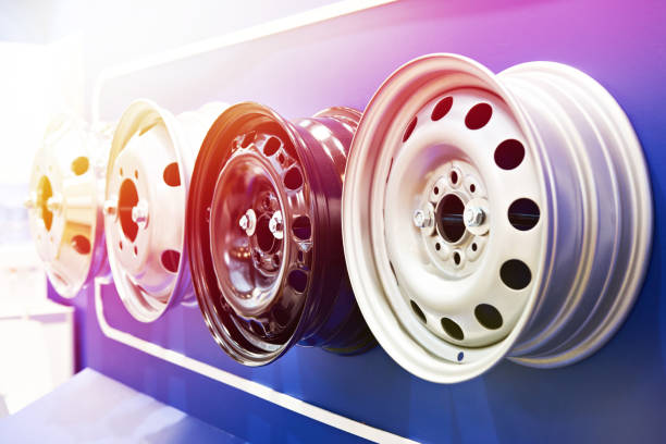металлические штампованные диски для автомобилей в магазине - wheel alloy alloy wheel tire стоковые фото и изображения