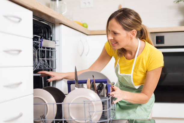 istock Smiling woman using dishwasher in the kitchen. 1017594760
