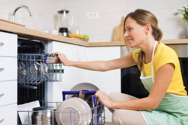 istock Smiling woman using dishwasher in the kitchen. 1017596862