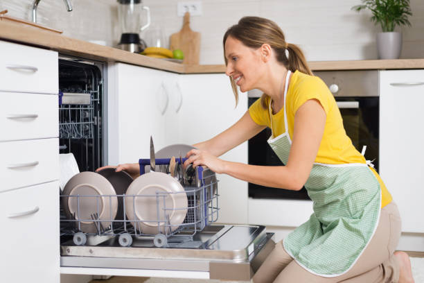 istock Smiling woman using dishwasher in the kitchen. 1017598960