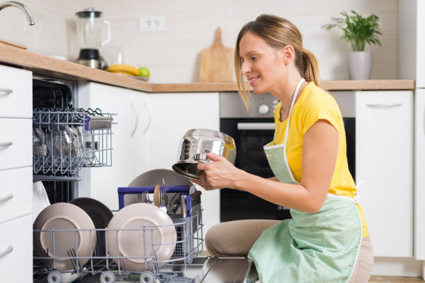 istock Smiling woman using dishwasher in the kitchen. 1017599092